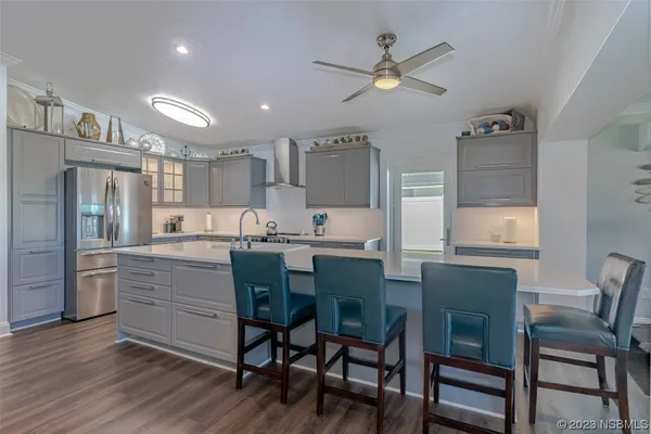 a kitchen with a dining table chairs refrigerator and cabinets