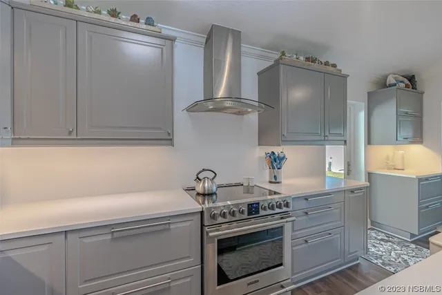 a kitchen with stainless steel appliances a stove and white cabinets