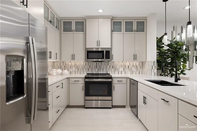 a kitchen with stainless steel appliances granite countertop a sink stove and refrigerator