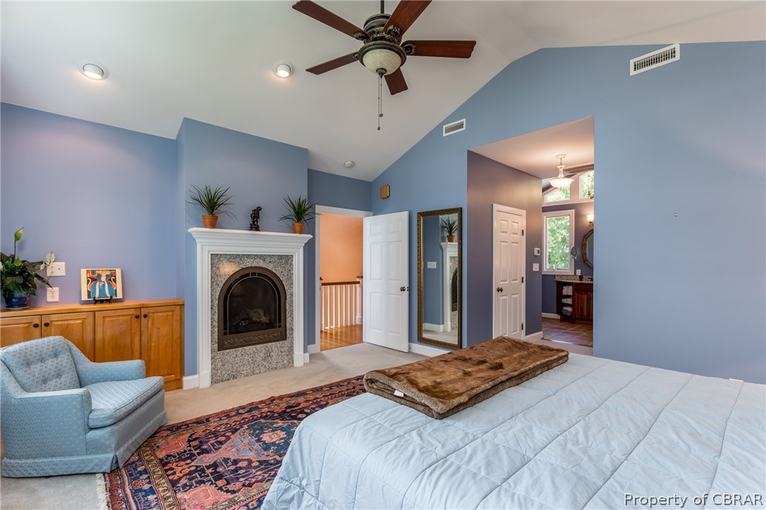 901 Oak Hill Road Lancaster, VA 22503 - Photo 35 of 49 a spacious bedroom with a large bed a chandelier and a couch