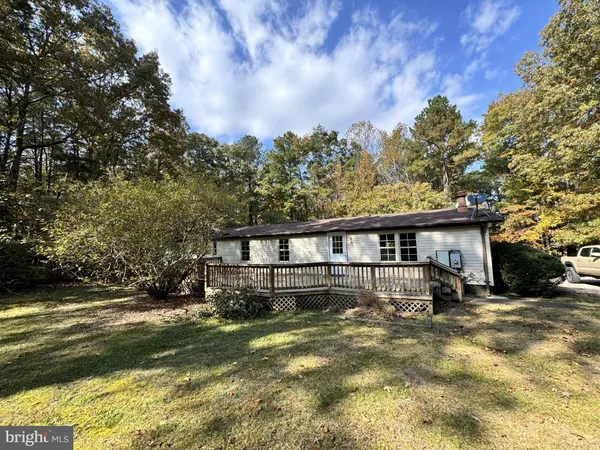 a view of a house with a backyard and a tree