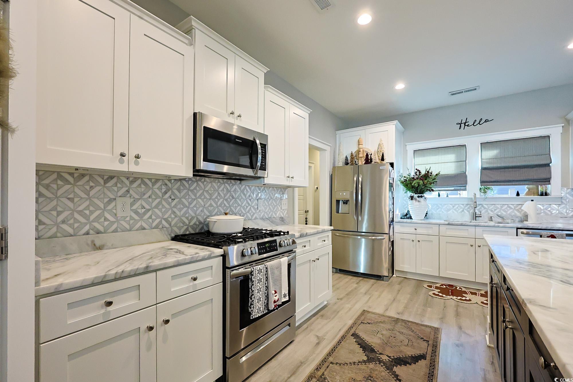 669 Pacific Commons Drive Surfside Beach, SC 29575 - Photo 6 of 36 Kitchen featuring white cabinets, appliances with stainless steel finishes, light stone counters, decorative backsplash, and recessed lighting