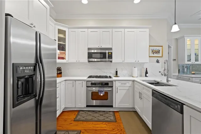 a kitchen with stainless steel appliances granite countertop a stove a refrigerator and a sink