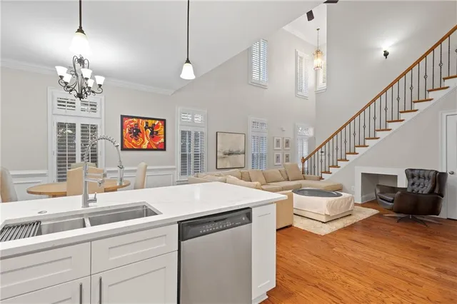 a view of a livingroom with furniture a chandelier and wooden floor