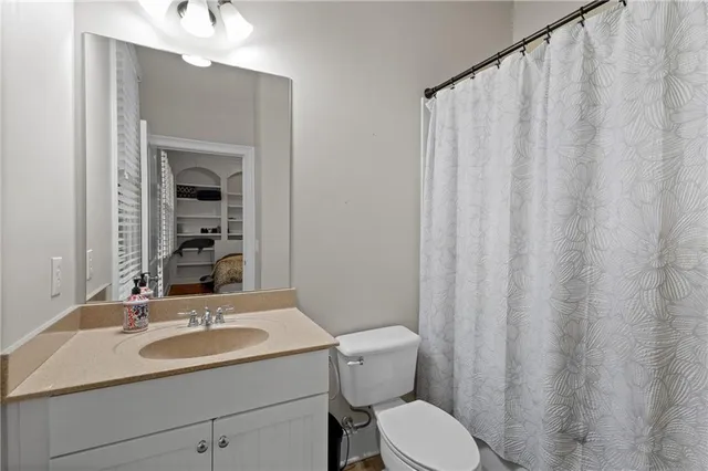 a bathroom with a sink a toilet and shower curtain
