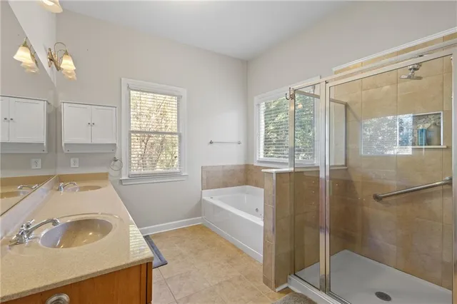 a spacious bathroom with double vanity and a mirror