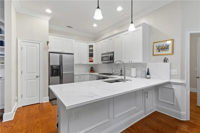 a kitchen with a sink stainless steel appliances a refrigerator and cabinets