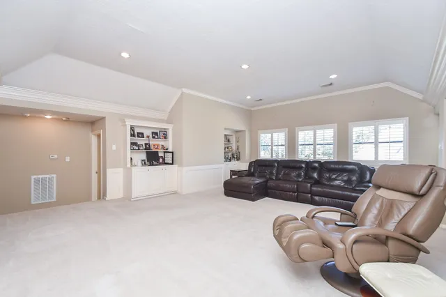 a bedroom with a bed a chandelier and dresser