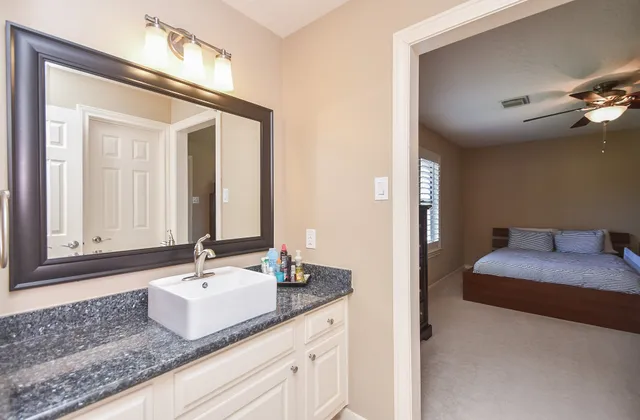 a bathroom with a granite countertop sink and a mirror