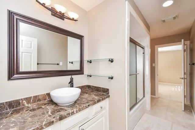 a bathroom with a granite countertop sink and a mirror