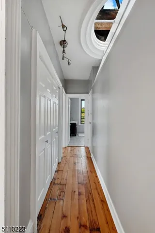 a view of a hallway with wooden floor