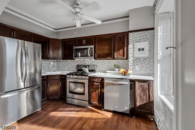 a kitchen with stainless steel appliances granite countertop a refrigerator a stove a sink and a microwave