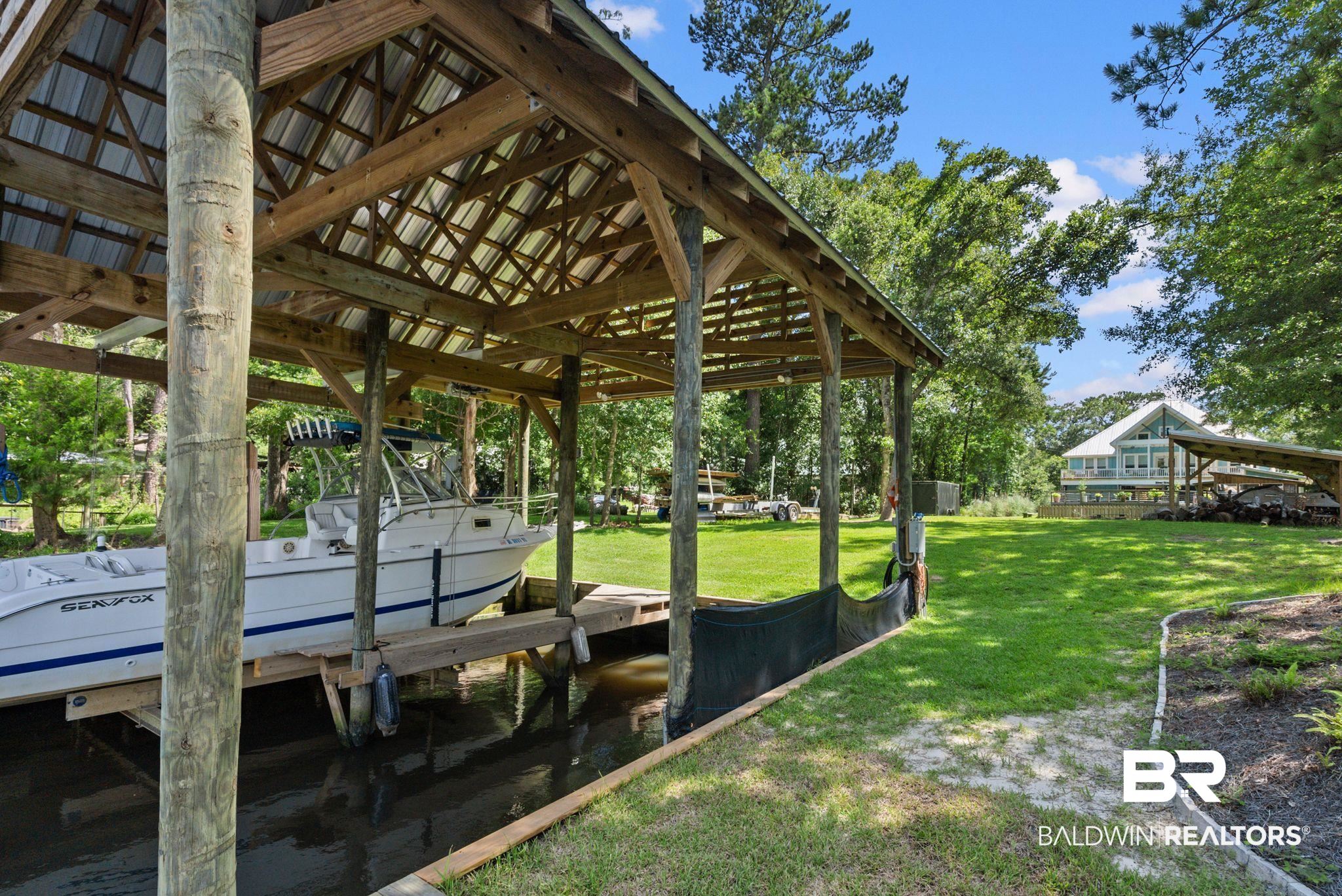 7266 Franklin Road Foley, AL 36535 - Photo 5 of 64 Waterfront property featuring a covered boat slip with a metal roof and a boat lift