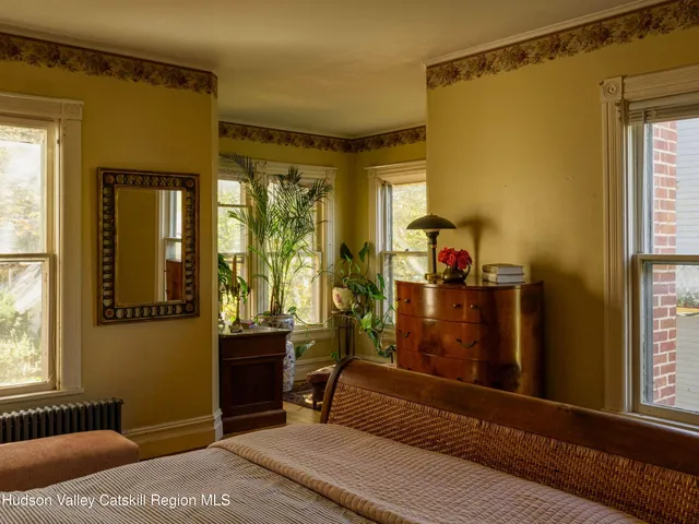 a living room with couches a flat screen tv and a dining table with garden view