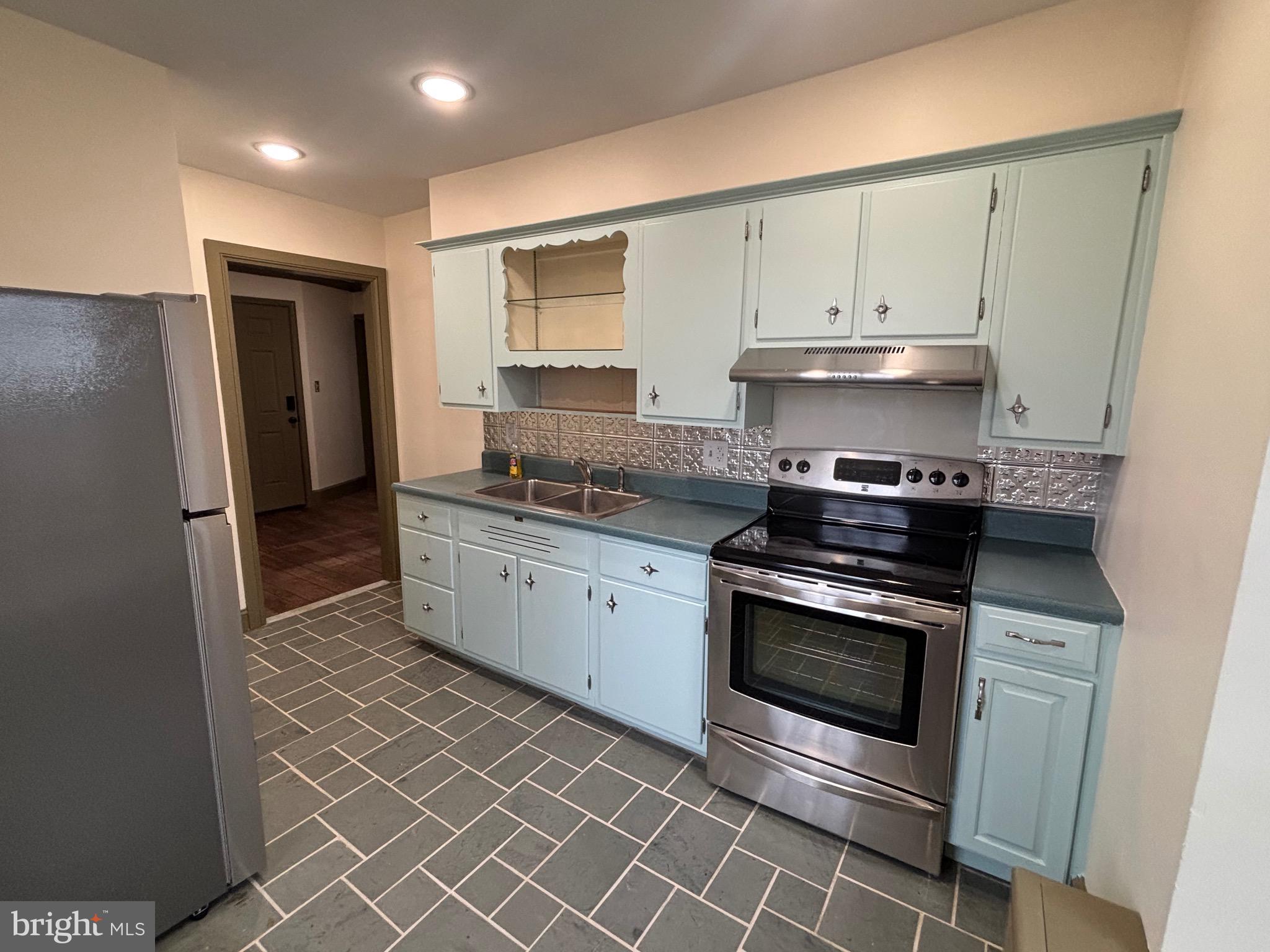 28 West Main Street, Unit 3 Elverson, PA 19520 - Photo 5 of 10 a kitchen with stainless steel appliances a stove a sink and a refrigerator