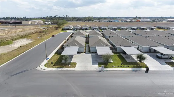 an aerial view of residential houses with outdoor space and ocean view