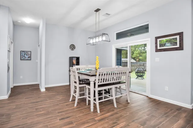 a dining room with furniture a chandelier and wooden floor