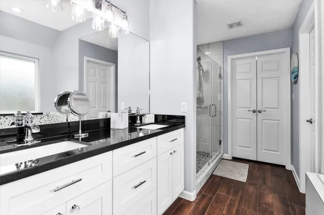 a bathroom with double sink and a mirror