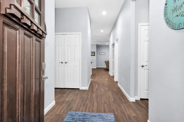 a view of a hallway with wooden floor and staircase