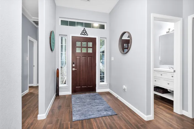 a view of a hallway with entryway wooden floor and front door