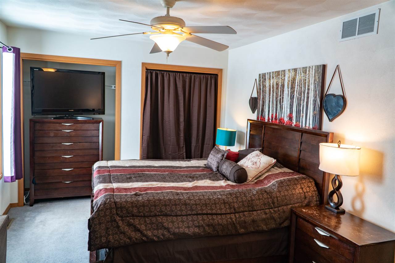 696 Bayfield Road Rockton, IL 61072 - Photo 13 of 20 a bedroom with a bed and a flat tv screen on dresser