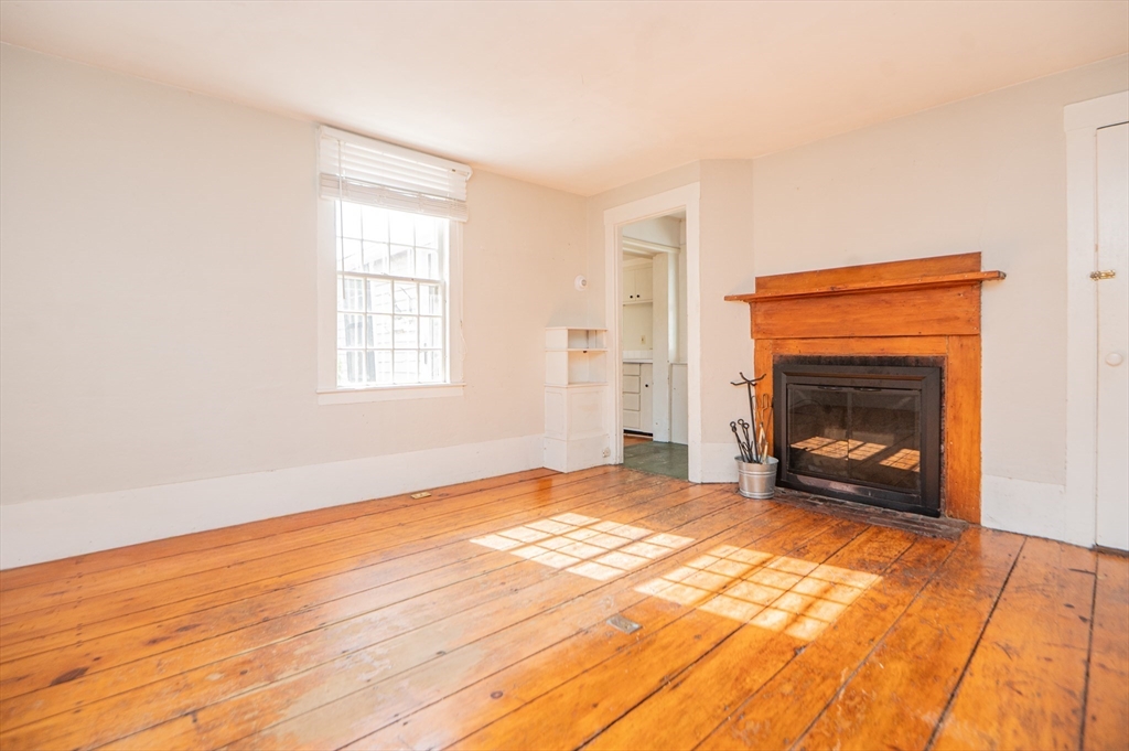 6 Merritt Street Marblehead, MA 01945 - Photo 4 of 31 a view of an empty room with wooden floor fireplace and a window