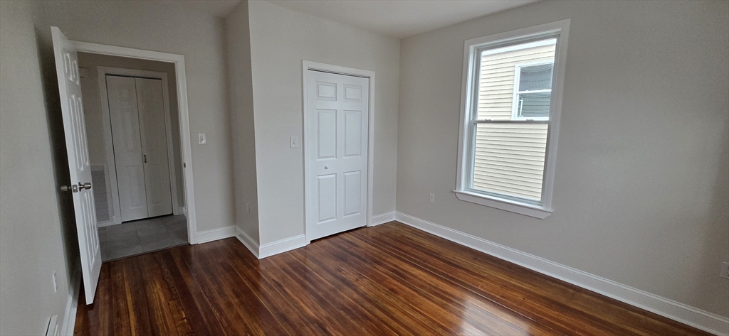 25 Bennett Street, Unit 2 Beverly, MA 01915 - Photo 11 of 17 a view of an empty room with wooden floor and a window