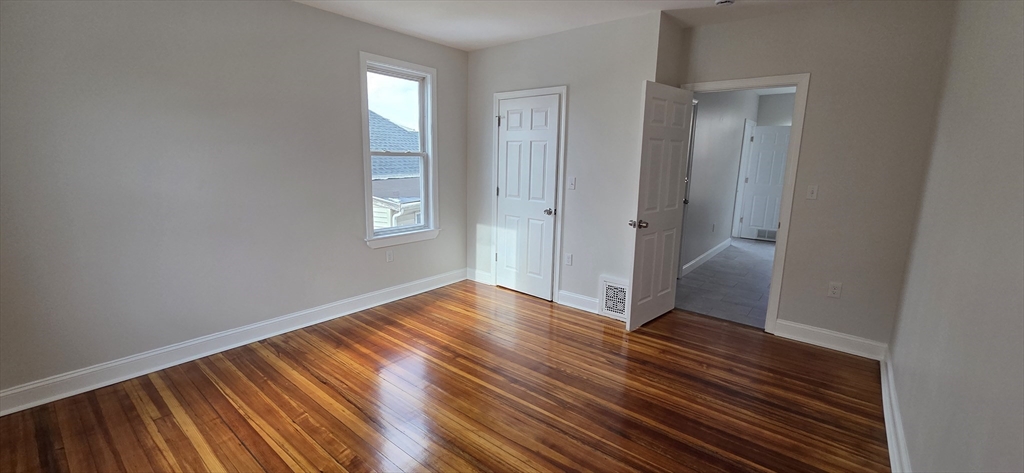 25 Bennett Street, Unit 2 Beverly, MA 01915 - Photo 12 of 17 a view of an empty room with wooden floor and a window