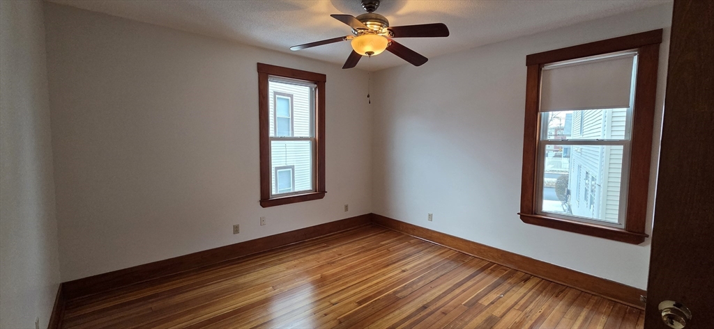 25 Bennett Street, Unit 2 Beverly, MA 01915 - Photo 17 of 17 a view of an empty room with window and wooden floor
