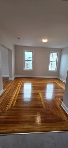 a view of empty room with window and hardwood floor