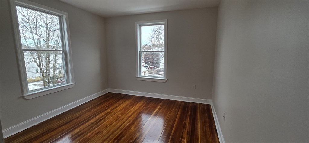 25 Bennett Street, Unit 2 Beverly, MA 01915 - Photo 10 of 17 a view of an empty room with wooden floor and a window