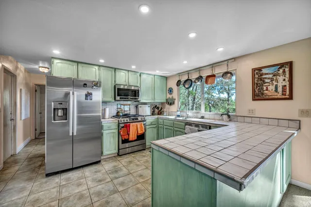 a kitchen with stainless steel appliances granite countertop a refrigerator and a sink