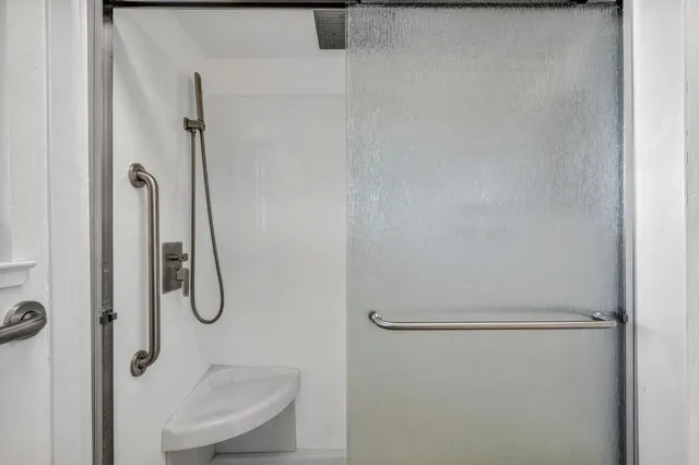 a view of a house with a small yard and large tree