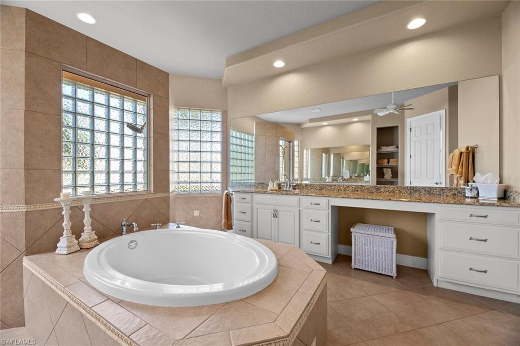 19260 La Serena Drive Estero, FL 33967 - Photo 28 of 48 a bathroom with a sink a bathtub a mirror a vanity and a window