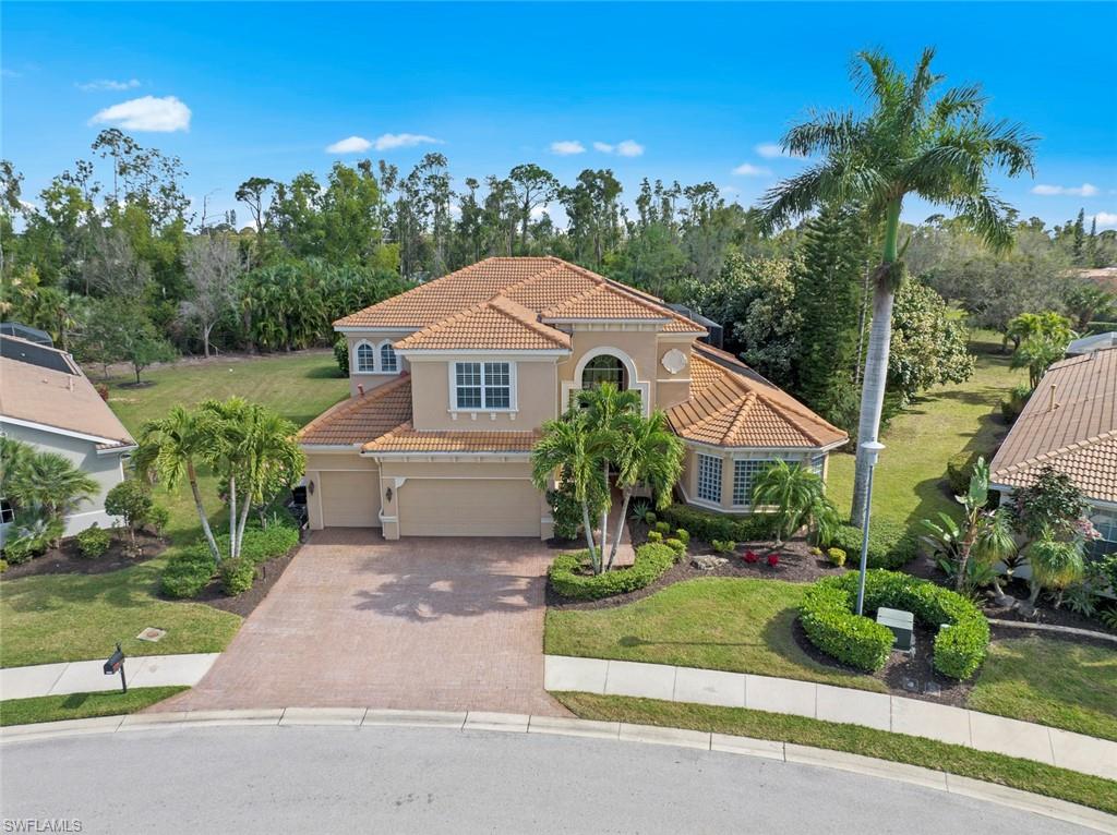 19260 La Serena Drive Estero, FL 33967 - Photo 7 of 48 a front view of a house with a yard and potted plants