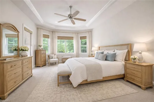 a spacious bedroom with a large bed and a chandelier