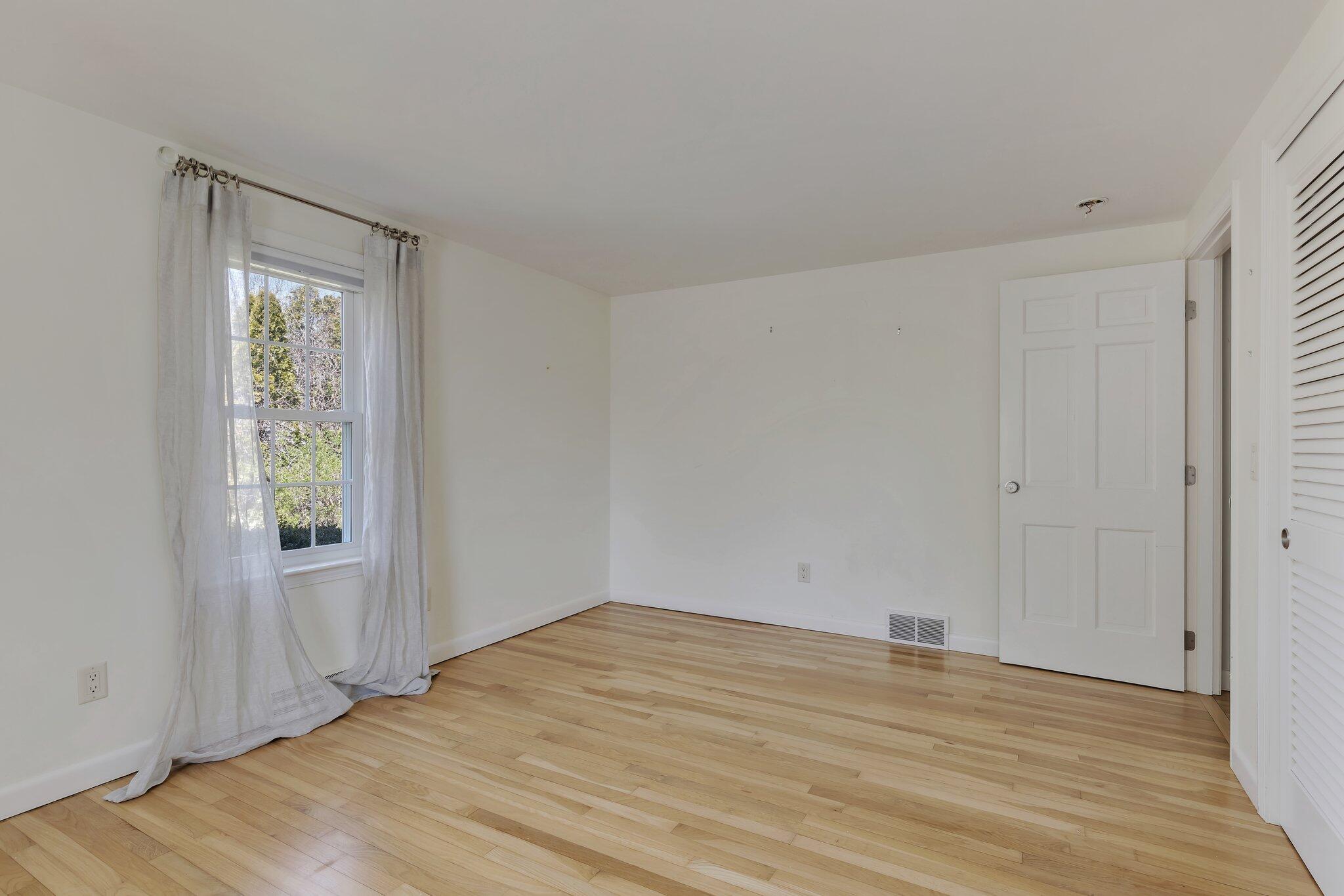 248 Chippingstone Road Chatham, MA 02633 - Photo 13 of 26 an empty room with wooden floor and windows