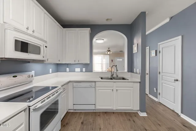 a kitchen with granite countertop a sink stainless steel appliances and cabinets