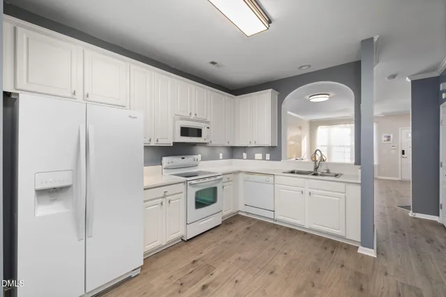 a kitchen with white cabinets and white appliances