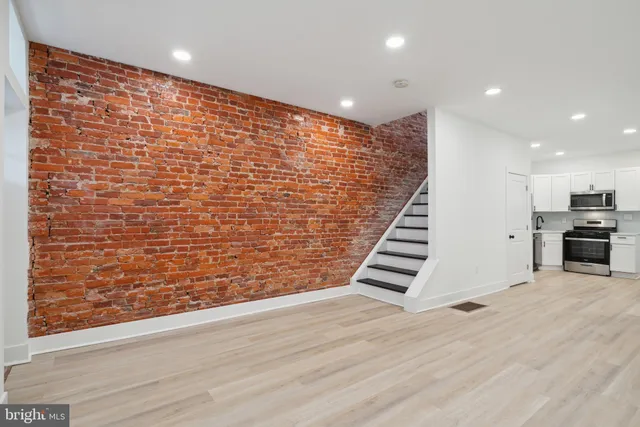 a view of a room with wooden floor and staircase