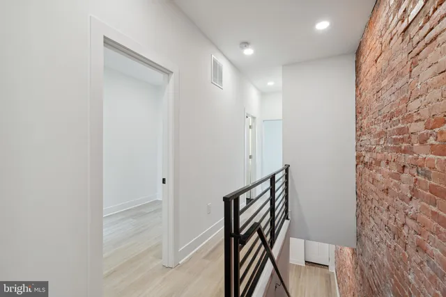 a view of a hallway with wooden floor and staircase