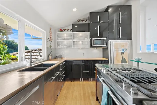 a kitchen with granite countertop a sink a stove and refrigerator