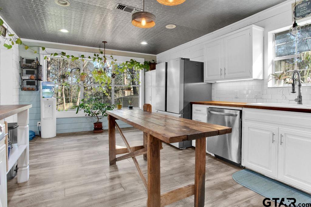 1339 Bridle Path Lane Hideaway, TX 75771 - Photo 16 of 41 a dining hall with stainless steel appliances granite countertop a kitchen island a stove a table and chairs in it
