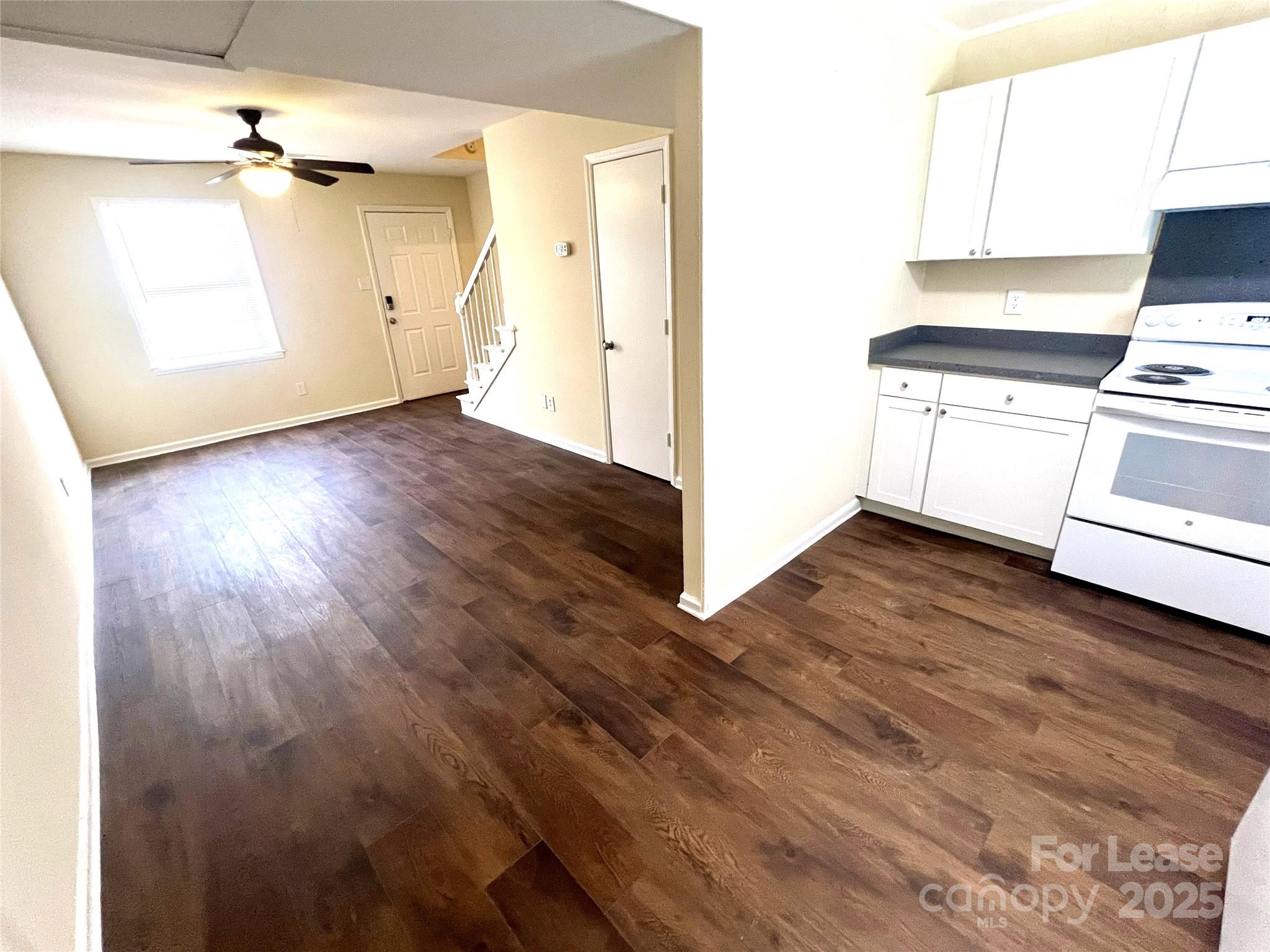 250 Nixon Road, Unit 34 Belmont, NC 28012 - Photo 5 of 11 an empty room with wooden floor cabinet and windows