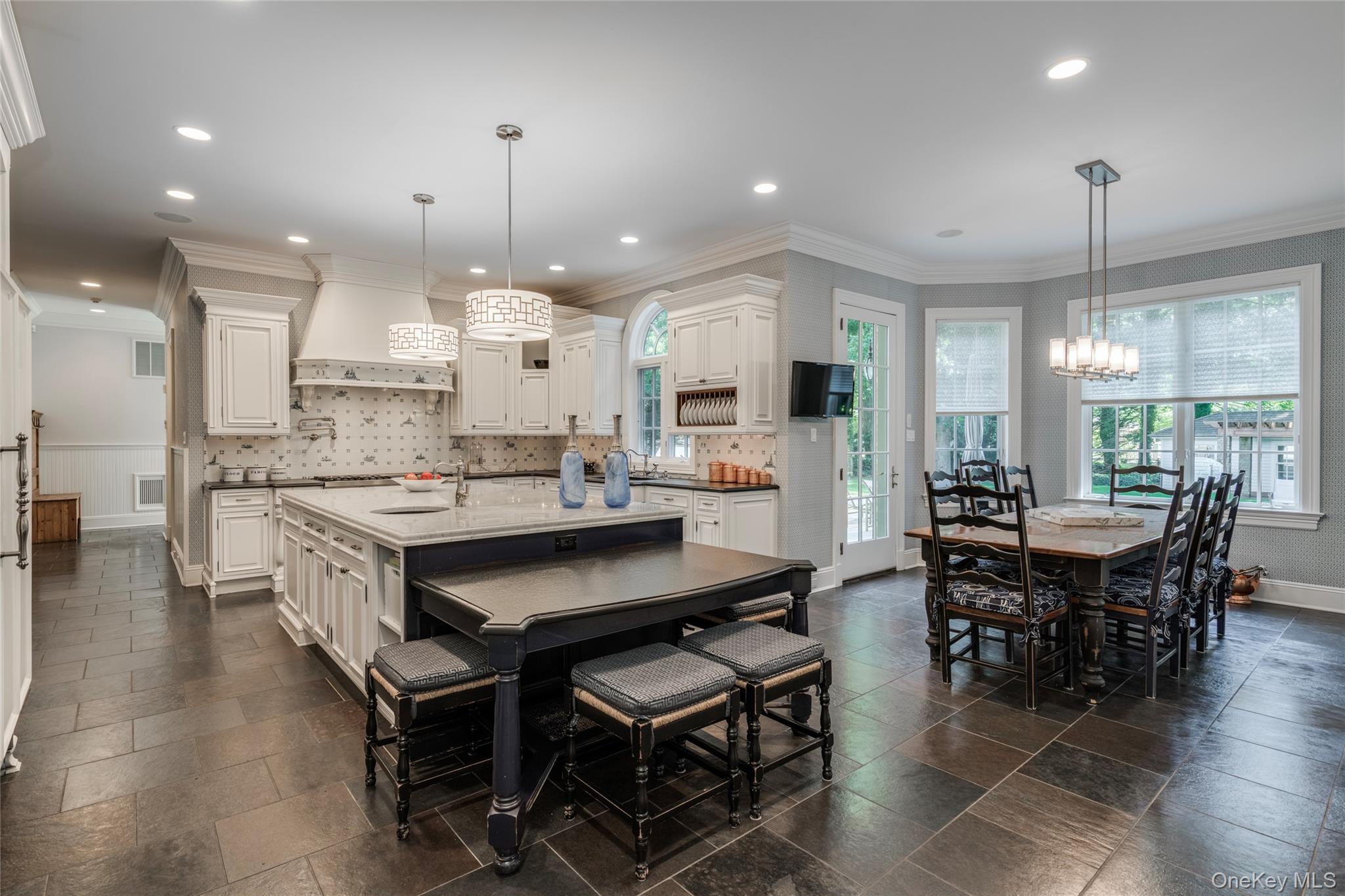 178 Brookville Road Muttontown, NY 11545 - Photo 11 of 29 a kitchen with kitchen island a dining table chairs and white cabinets
