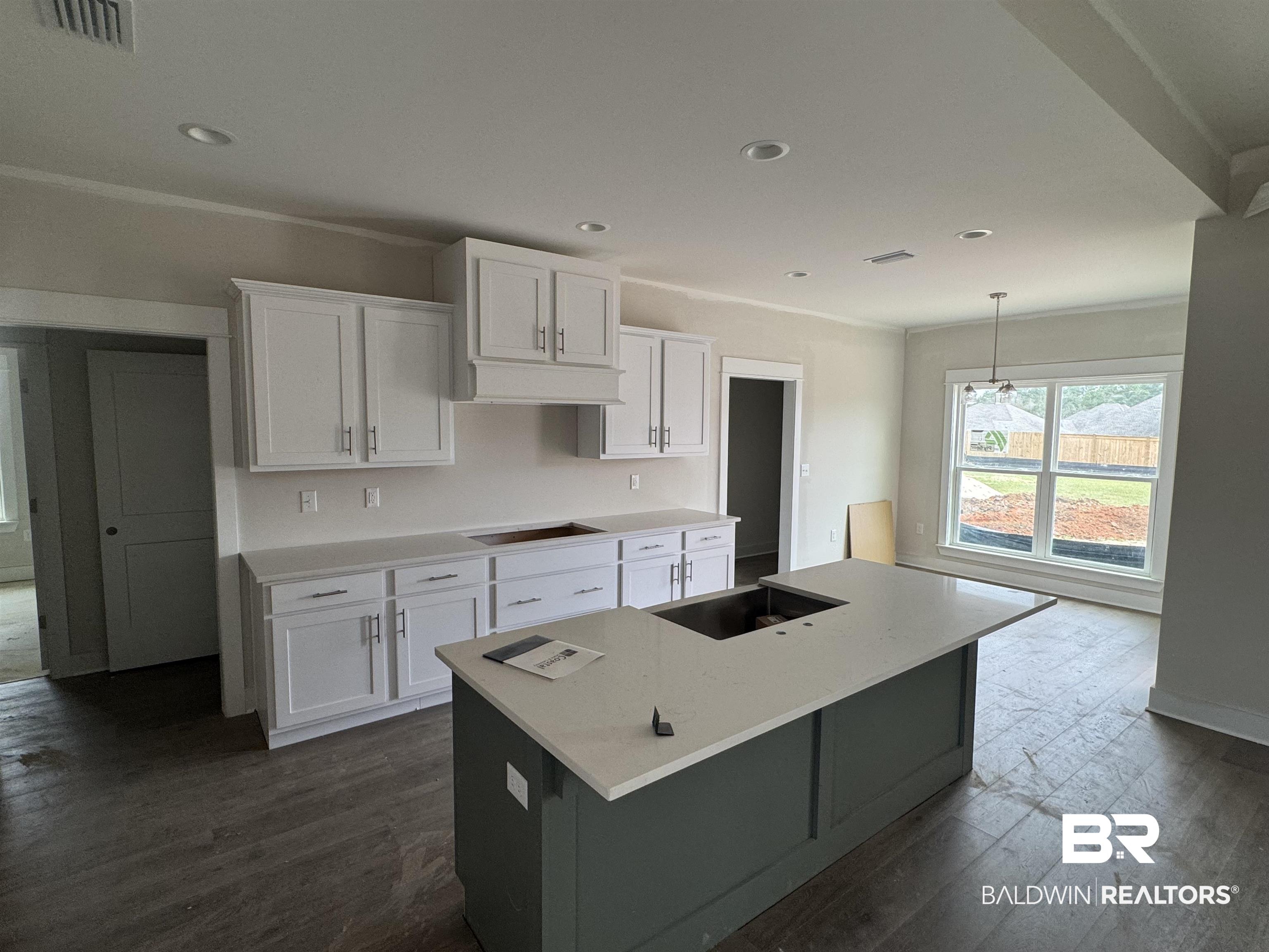 23579 Travis Stock Street Foley, AL 36535 - Photo 11 of 31 Kitchen with white cabinetry, a kitchen island with sink, and decorative light fixtures