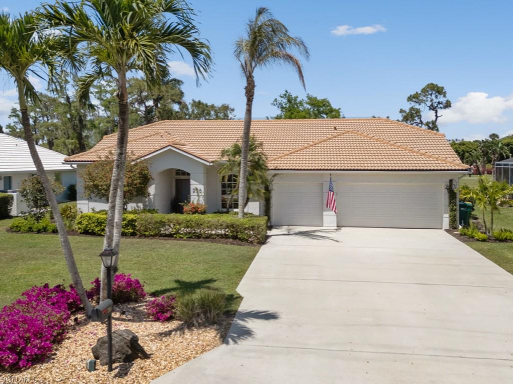 206 Palmetto Dunes Circle Naples, FL 34113 - Photo 1 of 34 a front view of a house with a yard
