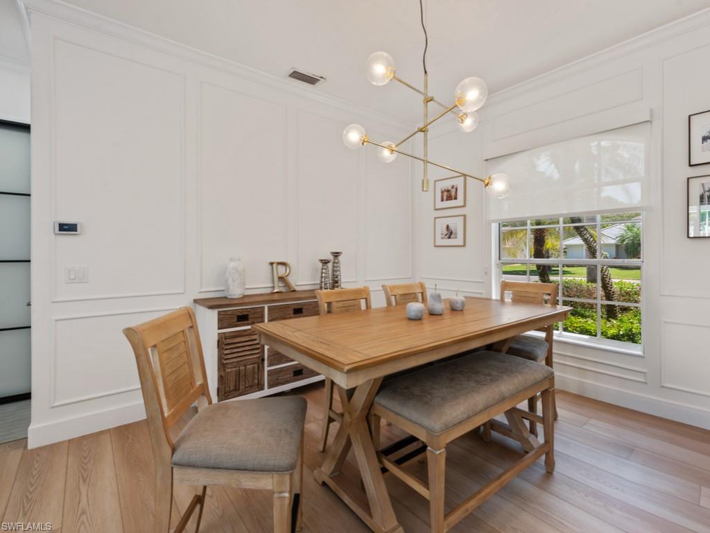206 Palmetto Dunes Circle Naples, FL 34113 - Photo 13 of 34 a view of a dining room with furniture and wooden floor