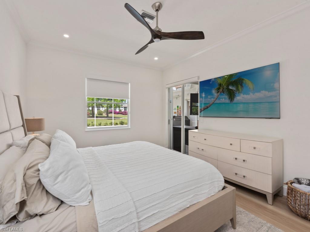 206 Palmetto Dunes Circle Naples, FL 34113 - Photo 16 of 34 a bedroom with a bed and a flat tv screen on dresser