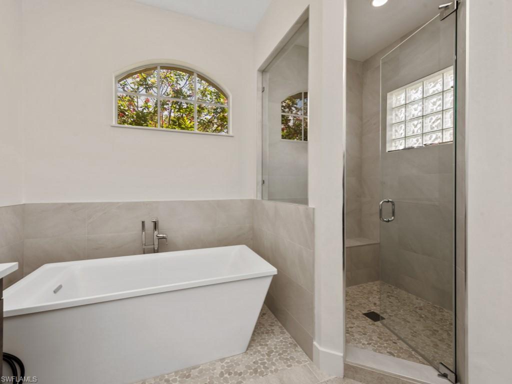 206 Palmetto Dunes Circle Naples, FL 34113 - Photo 18 of 34 a bathroom with a bathtub and a shower